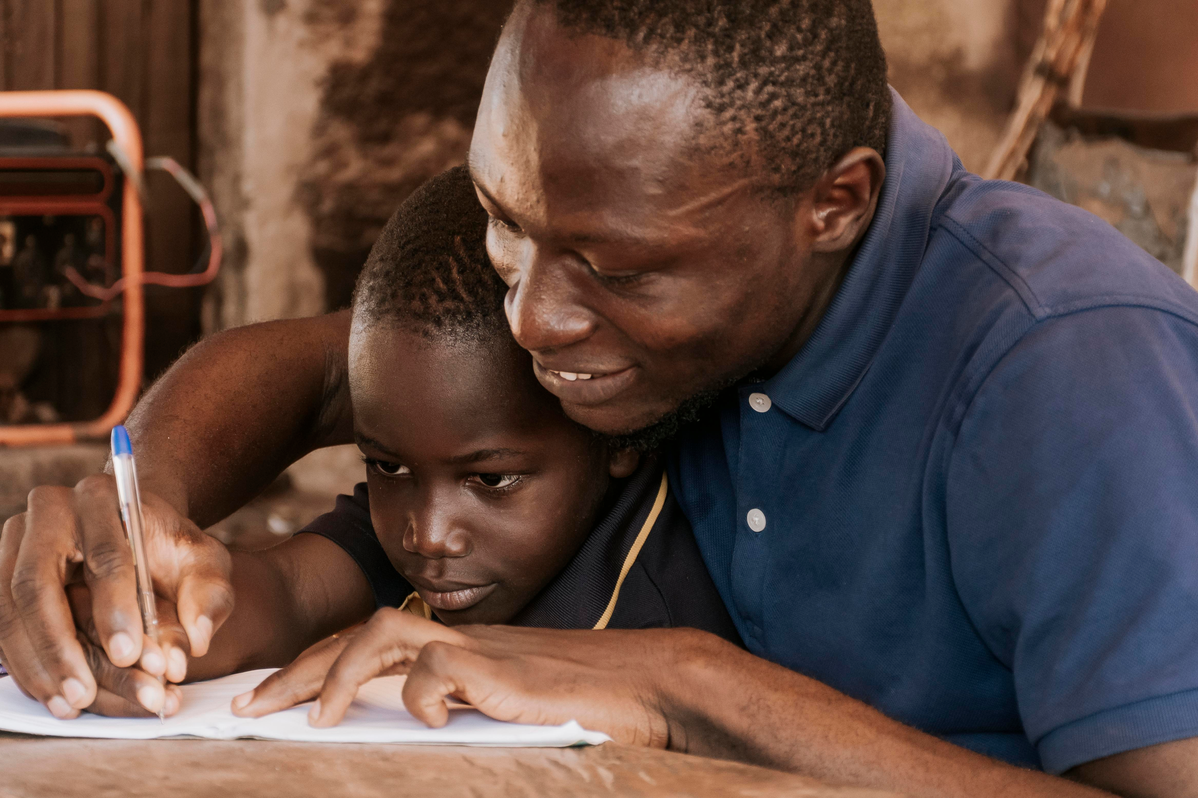 A teacher helping a child write